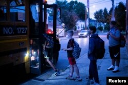 Students walk up to the school bus on the first day of school in Louisville, Kentucky, U.S. August 11, 2021.