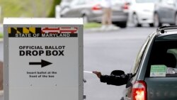 A motorist drops off a mail-in ballot outside of a voting center during the 7th Congressional District special election, Tuesday, April 28, 2020, in Windsor Mill, Md. (AP Photo/Julio Cortez)