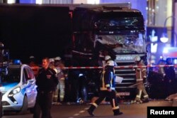 A firefighter walks in front of a truck at the site of an accident at a Christmas market on Breitscheidplatz square near the fashionable Kurfuerstendamm avenue in the west of Berlin, Germany, Dec. 19, 2016.