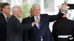 Vice President Mike Pence, left, with Prime Minister of Montenegro Dusko Markovic, center, wave to members of the media outside the West Wing of the White House in Washington, June 5, 2017.