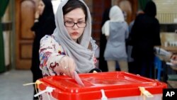 An Iranian woman casts her ballot for the parliamentary runoff elections in a polling station at the city of Qods about 12 miles (20 kilometers) west of Tehran, April 29, 2016.