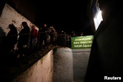 A group of Hungarians who take part in an organized tour to learn about Budapest's Muslim community walk out from a small mosque at an apartment building in Budapest, Hungary, Nov. 3, 2017.