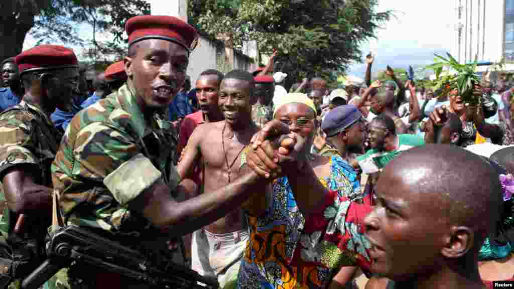 La foule salue les soldats alors qu&#39;elle célèbre après l&rsquo;annonce de la destitution du président Pierre Nkurunziza par un haut gradé de l&rsquo;armée à Bujumbura, au Burundi le 13 mai 2015.