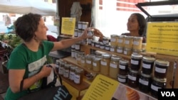 Immigrants have been a large part of the market's resurgence in the last 30 years. Originally from Nepal, Susan Dahl sells honey. (J. Soh/VOA)