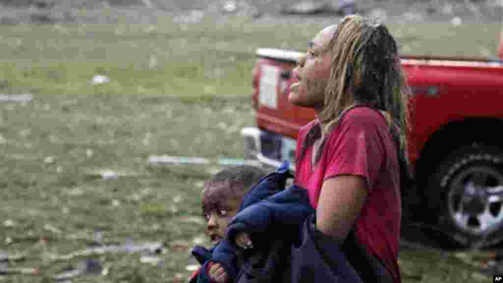 A woman carries an injured child to a triage center near the Plaza Towers Elementary School in Moore, Okla., Monday, May 20, 2013.