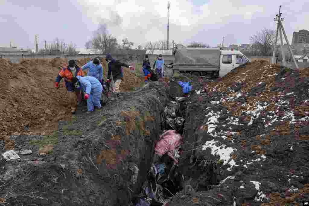 Dead bodies are put into a mass grave on the outskirts of Mariupol, Ukraine, March 9, 2022 as people cannot bury their dead because of the heavy shelling by Russian forces.