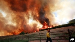 Emergency crews battle a running wildfire that is threatening a home on April 19, 2011 in Strawn, Texas.