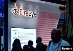 Attendees walk by the FireEye booth during the 2016 Black Hat cyber-security conference in Las Vegas, Nevada, Aug. 3, 2016.