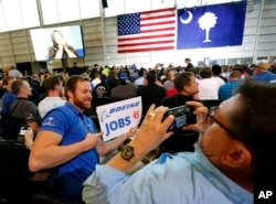 Patrick Brothers, left, smiles for the camera as Wendell Bailey, takes his photo as the two Boeing employees wait with others for President Donald Trump to speak, Feb. 17, 2017, in the final assembly building at Boeing South Carolina in North Charleston.