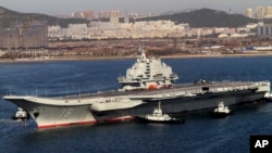 FILE - Chinese aircraft carrier Liaoning cruises back to port after its first navy sea trial in Dalian, northeastern China.