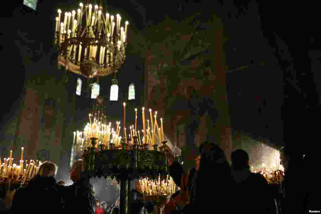 People light candles during a Mass on Christmas at Alexander Nevski cathedral in Sofia, Bulgaria, Dec. 25, 2016.