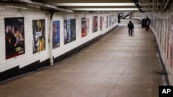 A man walks through an empty underground passage in the Brooklyn borough of New York, Monday, March 16, 2020. (AP Photo/John Minchillo)
