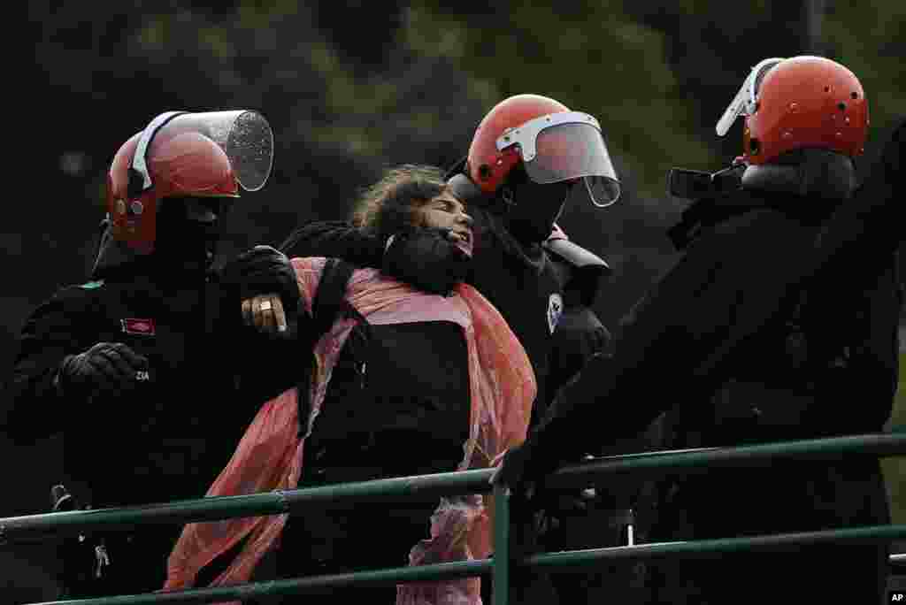 Basque police detain alleged member of the Basque armed group ETA, Urtza Alkorta, wearing pink plastic on her body, as she stands on a bridge with some hundreds of her supporters, in Ondarroa, northern Spain.