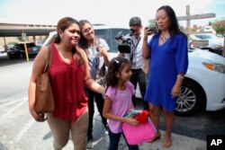 Cindy Madrid, from El Salvador, and her 6-year-old daughter Allison walk into a news conference in Houston, July 13, 2018, to discuss their reunion after being separated at the U.S.-Mexico border.