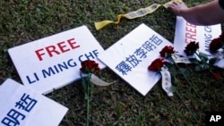 FILE - Roses and slogans reading ''Free Lee Ming-che'' are placed on the lawn during a media event to support Taiwanese activist Lee Ming-che detained in China, in Taipei, Taiwan, Nov. 28, 2017. 