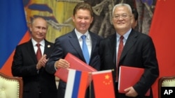 2014年5月21日俄羅斯總統普京（左）、俄羅斯天然氣工業股份公司首席執行官阿列克謝•米勒（中）與中國石油集團主管周吉平在中國上海中俄天然氣協議簽字儀式上