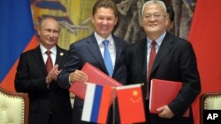 2014年5月21日俄罗斯总统普京（左）、俄罗斯天然气工业股份公司首席执行官阿列克谢·米勒（中）与中国石油集团主管周吉平在中国上海中俄天然气协议签字仪式上