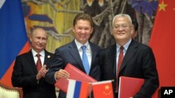 Presiden Rusia Vladimir Putin (kiri), CEO perusahaan gas Rusia Gazprom Alexei Miller (tengah) dan pimpinan perusahaan minyak China (CNPC) Zhou Jiping seusai penandatanganan perjanjian gas antara kedua negara di Shanghai, China (21/5).