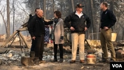 U.S. President Donald Trump visits the wreckage of a mobile home park in Paradise, Calif., Nov. 17, 2018, with FEMA chief Brock Long, right. At left, California Gov. Jerry Brown talks with Paradise Mayor Jody Jones, and behind them is Gov.-elect Gavin Newsom. (S. Herman/VOA)