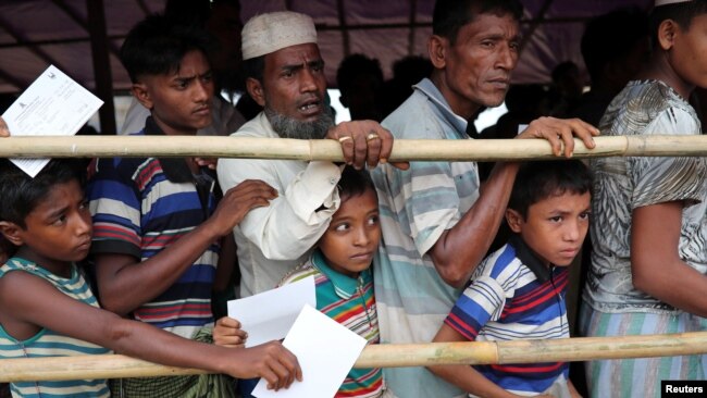在孟加拉国的难民营，罗兴亚难民等待救济中心发肉。（2018年8月23日）