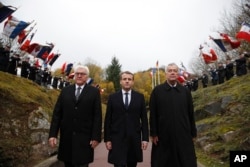 FILE - French President Emmanuel Macron, center, and German President Frank-Walter Steinmeier left, attend a WWI ceremony at the World War I Vieil Armand "Hartmannswillerkopf" battlefield in the Alsace region, eastern France, Nov. 10, 2017. The official at right is unidentified.