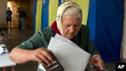 An elderly woman casts her vote in the presidential election in the eastern town of Krasnoarmeisk, Ukraine, May 25, 2014.