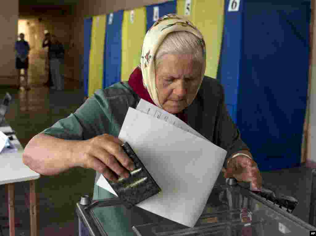 An elderly woman casts her vote in the presidential election in the eastern town of Krasnoarmeisk.