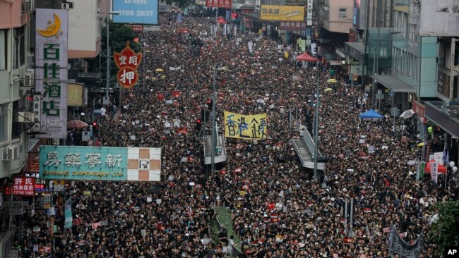 Tens of thousands of protesters march through the streets as they continue to protest an extradition bill, Sunday, June 16, 2019, in Hong Kong. (AP Photo/Vincent Yu)