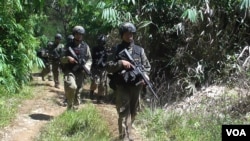 Pasukan Brimob berjalan kaki di hutan Desa Pantangolemba, Kabupaten Poso, Sulawesi Tengah. (VOA/Yoanes Litha)