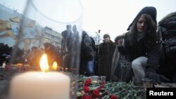 People lay flowers as they attend a rally to commemorate the victims of the deadly suicide bombing at Moscow's Domodedovo airport, January 27, 2011.