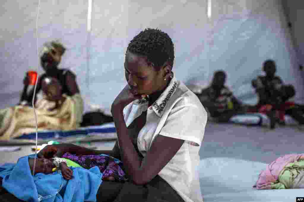 A mother sits with her infant in a clinic run by Doctors Without Borders (MSF) in Minkammen, 25 kilometers (16 miles) south of Bor. Some 80,000 displaced people from the volatile South Sudan region have fled to safety in sprawling, dusty camps in the Awerial region across the Nile River. 