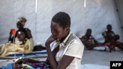 A mother sits with her infant in a clinic run by Doctors Without Borders (MSF) in Minkammen, 25 kilometers (16 miles) south of Bor, Jan. 10, 2014.