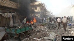 People inspect a site hit by what activists said were barrel bombs dropped by forces loyal to Syria's President Bashar al-Assad in the northern town of Atareb, in Aleppo province, Apr. 24, 2014. 