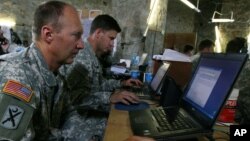 FILE - U.S. soldiers monitor battlefield conditions at a joint military command center. Many experts say U.S.-Russian military cooperation in Syria is fraught with risks but they see few alternatives.