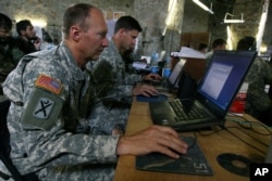 FILE - U.S. soldiers monitor battlefield conditions at a joint military command center in Ghazni province, west of Kabul, Afghanistan.