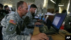 FILE - US soldiers monitor battlefield conditions at a joint military command center. Many experts say U.S.-Russian military cooperation in Syria is fraught with risks but they see few alternatives.