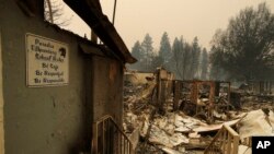 A sign hangs on a wall at the Paradise Elementary School destroyed by the Camp Fire, Tuesday, Nov. 13, 2018, in Paradise, Calif. (AP Photo/John Locher)