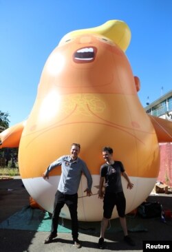 Leo Murray dan Matt Bonner berpose di depan balon helium mirip Donald Trump yang mereka harapkan akan diterbangkan dalam lawatan Presiden AS nanti, di London, 26 Juni 2018.