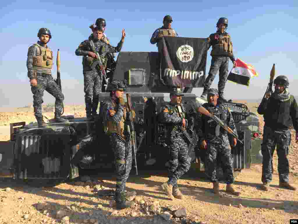 Dakarun kasar Iraqi na bikin murna akan shawo kan 'yan kungiyar ISIS yayin da suke rike da tutar 'yan ISIS a garin Mosul, ranar 23 ga watan Fabrairu, 2017 (K. Omar/VOA)