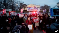 FILE - People protest President Trump's new travel ban order in Lafayette Park outside the White House, March 6, 2017.