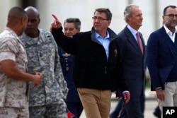 US Secretary of Defense Ashton Carter, center, and Spain's Defense Minister Pedro Morenes, right, walk together during their visit at Moron Airbase, near Seville, Spain, Oct. 6, 2015.