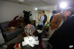 Reporters and photographers crowd into the living room of an apartment in Redlands, Calif., shared by San Bernardino shootings suspects Syed Farook and his wife, Tashfeen Malik, Dec. 4, 2015.