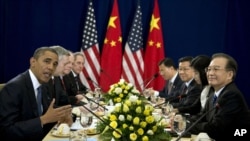美國總統奧巴馬（左）星期二在柬埔寨金邊舉行的東亞首腦會議上與中國國務院總理溫家寶（右）會晤