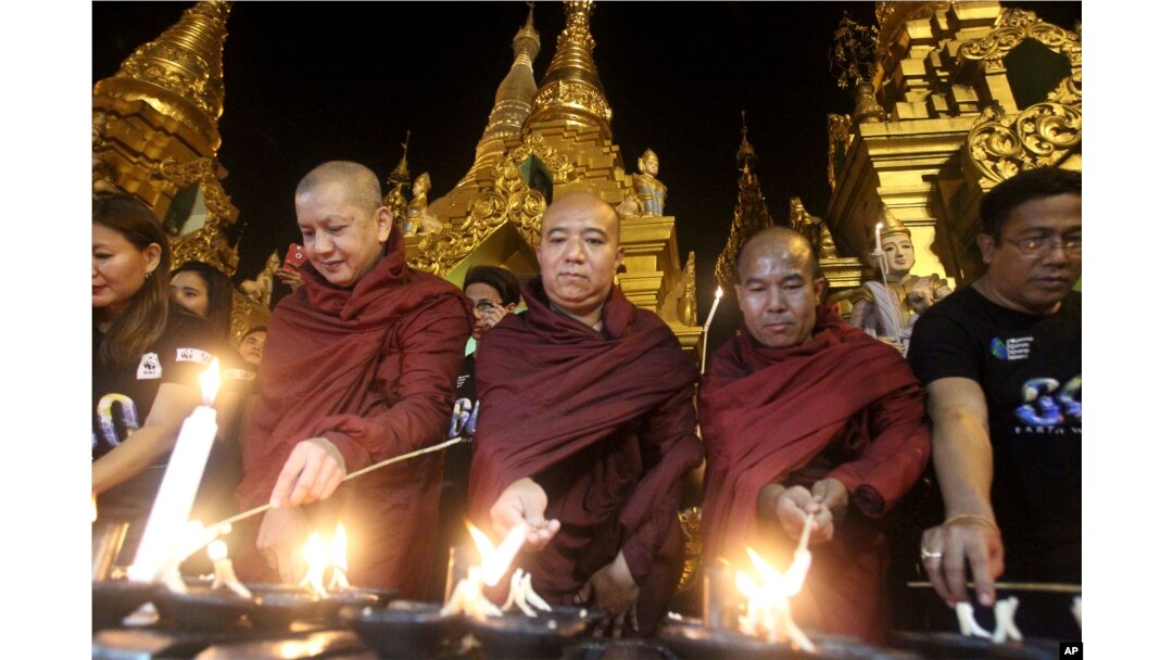Buddhist monks light oil lamps during Earth Hour celebrations at Myanmar's Shwedagon pagoda in Yangon, March 25, 2017.