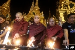 Buddhist monks light oil lamps during Earth Hour celebrations at Myanmar's Shwedagon pagoda in Yangon, March 25, 2017.