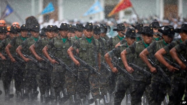 Soldados marchando bajo la lluvia durante una ceremonia militar en reconocimiento del nuevo presidente de Guatemala, Alejandro Maldonado, el 4 de septiembre, de 2015.