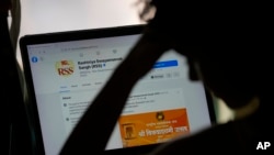 A girl looks at the face book page of Rashtriya Swayamevak Sangh or RSS, in New Delhi, India, Oct. 24, 2021.