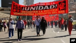 Workers march in front of a banner with a message that reads in Spanish "The fist of unity, defeating the traitorous policies of MAS (ruling party)," during a May Day march, in La Paz, Bolivia, May 1, 2015.