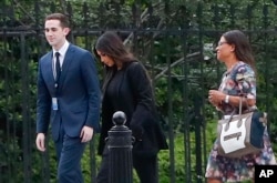 FILE - Kim Kardashian, center, arrives with her attorney Shawn Chapman Holley at the security entrance of the White House in Washington, May 30, 2018.