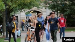 FILE - Students walk on campus at the University of Michigan in Ann Arbor, Michigan, Sept. 19, 2018. 